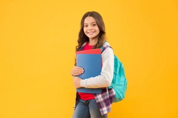 Happy school child hold study books on September 1 yellow background, back to school — Stock fotografie