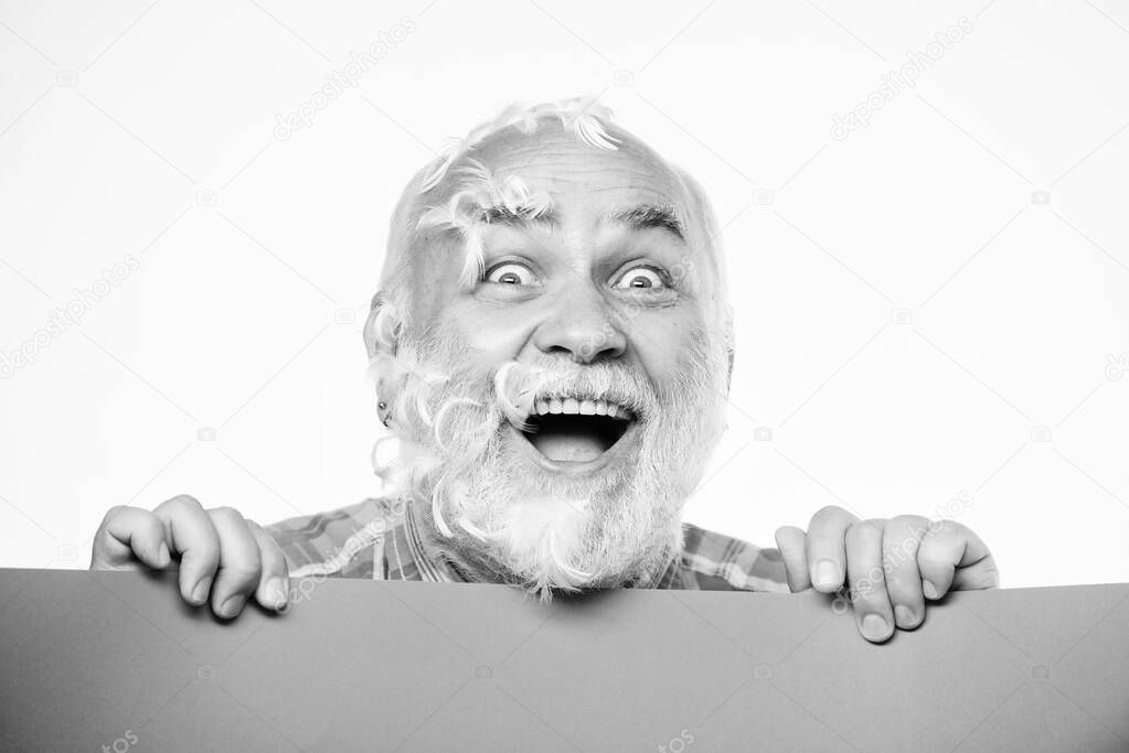 Pillow party. Soft feathers on his cheeks. Facial hair. Feathers madness. Man bearded mature emotional face with stuck white feathers close up. Funny pensioner going crazy. Advertisement concept
