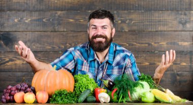 Çiftçi köylü tarzı adam. Doğal gıdalar. Vejetaryen yaşam tarzı konsepti. Sakallı çiftçi ahşap arka plan hasat ediyor. Çiftliğime hoş geldiniz. Evde yetişen sebzeli çiftçi. Sebzeler organik hasat