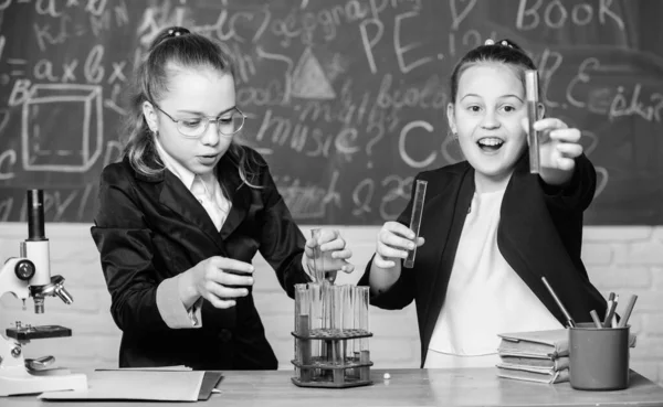 Tenga cuidado realizando la reacción química. Conocimiento básico de la química. Las chicas estudian química. Haz que estudiar química sea interesante. Concepto de experimento educativo. Microscopio y tubos de ensayo en la mesa — Foto de Stock