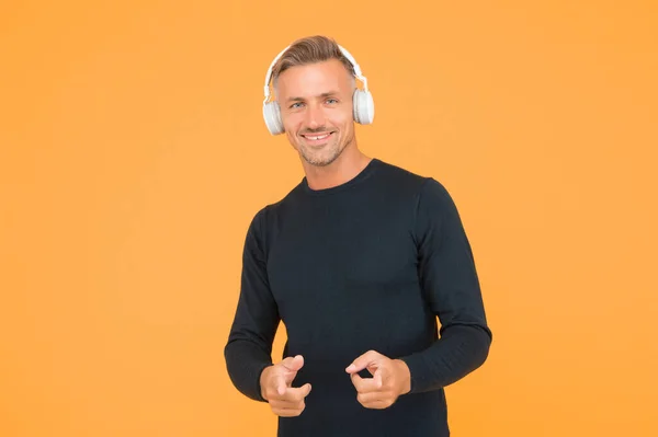 Macho feliz guapo con buena sonrisa aconseja auriculares de alta calidad estar en buen estado de ánimo mientras escucha música en línea, dj —  Fotos de Stock