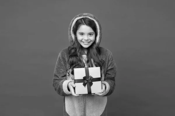 Щаслива дівчина-підліток у піжамі кролика Кігурумі тримає подарункову коробку, щасливий новий рік — стокове фото