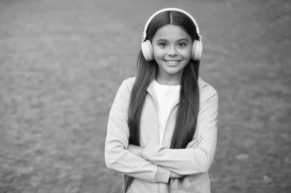 Alegre niño usar auriculares con música canción al aire libre disfrutando de la melodía, educación elearning — Foto de Stock