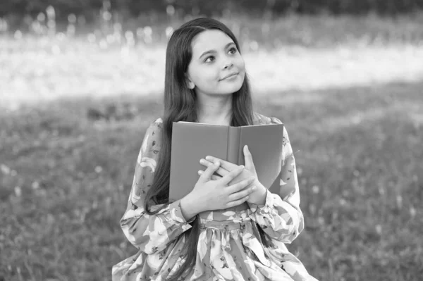 Kind meisje ontspannen buiten met boek, school huiswerk concept — Stockfoto