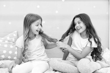 Çocuklar yatak odasında saçlarıyla neşeli bir oyun oynuyorlar. Mutlu çocukluk anları. Çocuklar kız kardeşler en iyi arkadaşlar enerji dolu neşeli ruh halindeler. Güçlü ve sağlıklı saçlar çıkar. Saç bakım konsepti. Güçlü saçlar.