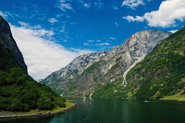 Agua entre acantilados de montaña con barcos o barcos turísticos. Laguna del río y altas montañas pedregosas impresionante atracción natural Homerswag. Aventura escandinava. Crucero alrededor de belleza escandinava — Foto de Stock