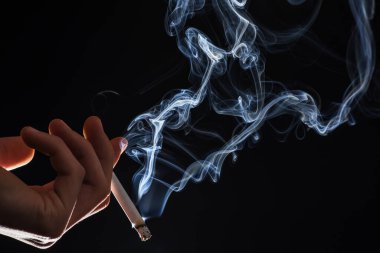 Tütün manyaktır. Erkek elinde dumanı tüten sigara. Sigara içme alışkanlığı. Tütün dumanı