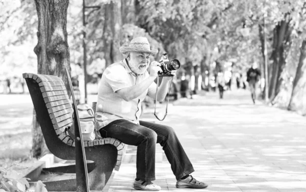 Conceito de turista. Viagens e turismo. O fotógrafo senta-se no banco no parque. Capturar a beleza da primavera. Desfrutando de tempo livre. Andar na sua rua favorita. Homem sênior segure câmera. Explore a cidade. Turismo hobby — Fotografia de Stock