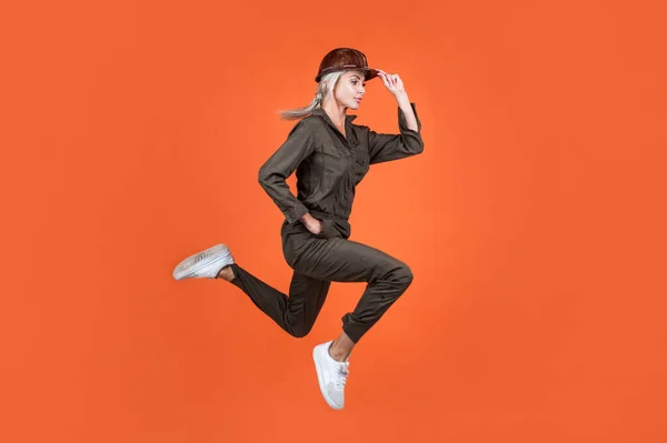 Jumping woman in working uniform and hard hat running hurry up on work, quality service — Stock Photo, Image