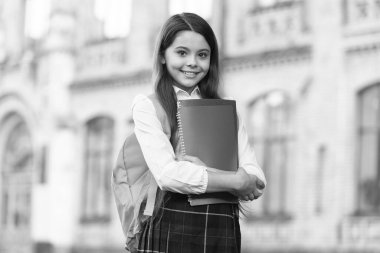 Küçük kız öğrenci üniforması ve sırt çantası kitapları, resmi eğitim konsepti.