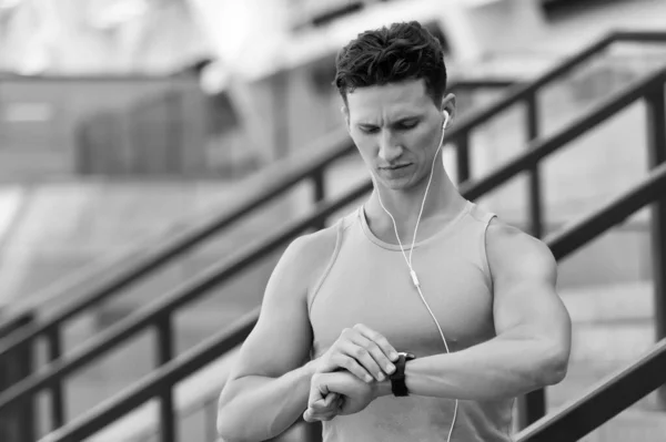 Guapo deportista configurar la aplicación de fitness con reloj inteligente — Foto de Stock