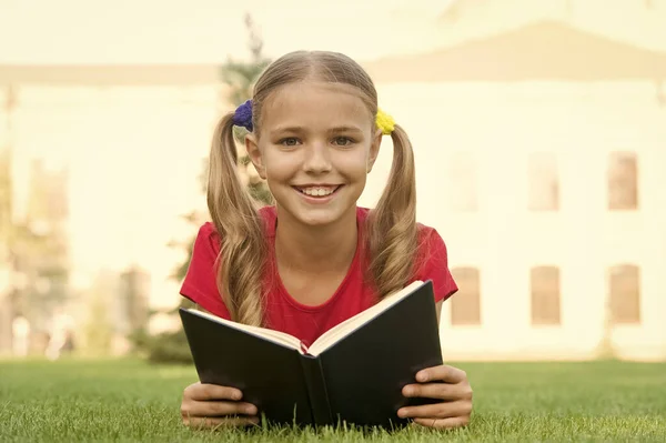 Otwórz wyobraźnię, czytaj. Szczęśliwy dzieciak czyta książkę o zielonej trawie. Rozwijanie wyobraźni. Wyobraźnia z dzieciństwa. Wyobraźnia i fantazja. Poznawcze umiejętności czytania. Letnie czytanie. Stań się pomysłowy — Zdjęcie stockowe