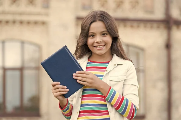 Η έξυπνη βιβλιοθήκη είναι ανοιχτή. Ευτυχισμένο παιδί κρατήσει βιβλίο βιβλιοθήκη σε εξωτερικούς χώρους. Το κοριτσάκι πάει στη βιβλιοθήκη. Σχολική βιβλιοθήκη. Σπουδάζει λογοτεχνία και γλώσσα. Ημέρα γνώσης. Βιβλιοπώλη. Βιβλιοπωλείο. Εκπαίδευση και σπουδές — Φωτογραφία Αρχείου