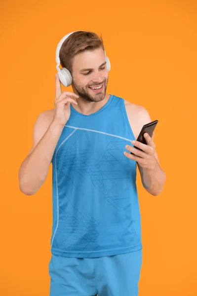 Homme sportif écouter de la musique smartphone. Playlist d'entraînement. Sport et fitness. Mode de vie actif. Santé et bien-être. Motivation d'entraînement. Suivi des progrès. Application pour les formations avec canapé en ligne — Photo