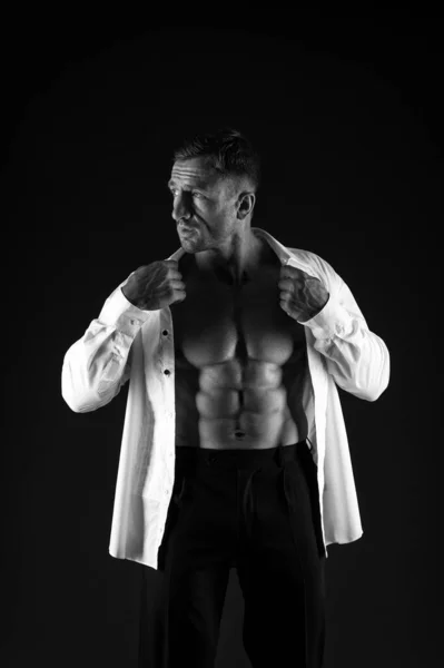 Adatto uomo mostra sei pack abs busto in camicia aperta stile formale sfondo nero, business — Foto Stock
