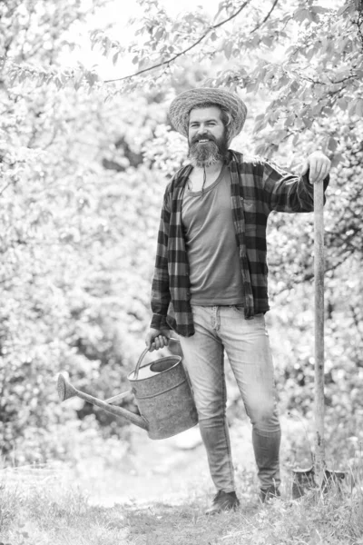 Gardening in vegetable garden. watering plants and flowers. Gardener digging with spade. mature agricultural worker with shovel and watering can. caucasian male farmer in country — Stock Photo, Image