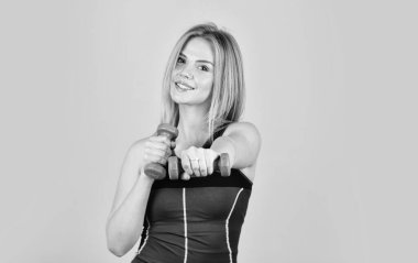 Antrenman motivasyonu. Formda kal. Sağlıklı bir vücut. Vücuduna dikkat et. Düşene kadar durma. Güzel bir kadın dambıllarla egzersiz yapıyor. Güçlü vücutlu atletik kız. Sporcu kadın konsepti