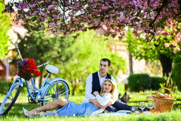 Страстная любовь. счастливая влюбленная пара. женщина и мужчина лежат в парке и наслаждаются днем вместе. Пикник в День Святого Валентина. романтический пикник в парке. Пара свиданий на одеяле под цветами сакуры. кемпинг — стоковое фото