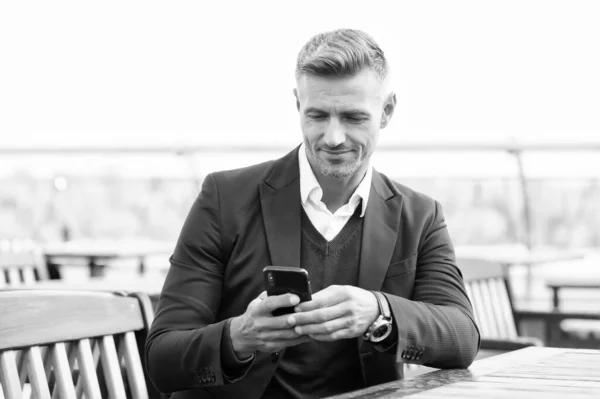 Encuesta SMS. Feliz hombre de negocios SMS de texto en la cafetería al aire libre. Mensajes SMS a través de teléfono inteligente. Reunión de negocios. Comunicación móvil. Mensajería SMS. Servicio de mensajes cortos. Nueva tecnología. La vida moderna. 3G. 4G — Foto de Stock