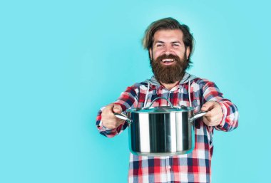 Yemek hazır. Bıyıklı sakallı adam mutfak aletleri kullanıyor. Sağlıklı yemek. Yapışmayan yüzey. Şef yemek yapıyor. Tavalı kareli gömlekli olgun bir adam. Şık erkek yemek pişirecek.