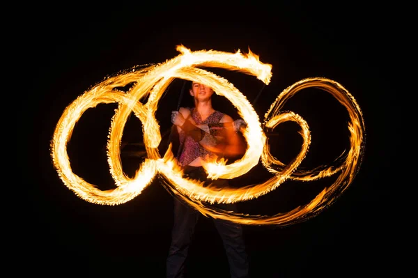 Man vuur danser twirl brandend stokje creëren sprankelende paden in beweging donker buiten, twirler — Stockfoto