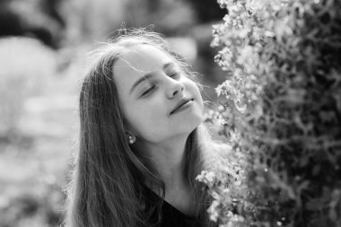 Doğanın tadını çıkarıyorum. Tatlı çocuk parkta vakit geçiriyor. Bahçeyi keşfet. Botanik bahçesine bir gezi. Bahar çiçeği kokusu. Genç kız botanik bahçesinde yürüyor. Huzurlu çevre bahçesi