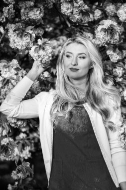 Tamamen rahatla. Parkta uzun saçlı bir kadın. Pembe kiraz ağacı çiçeği. Elbiseli güzel bir kadın. Çiçek açan sakura ağacı olan kız. Bahar modası. Gerçek kadın güzelliği. Yaz havası ve doğa