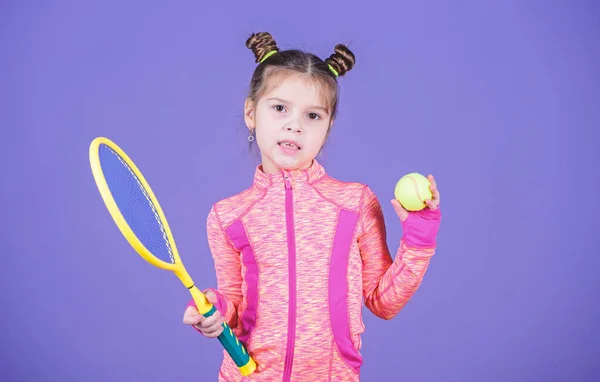 Sportnevelés. A kis cukipofa szereti a teniszt. Kis baba sportos jelmez teniszezni játék. Taníts meg teniszezni. Lány aranyos gyermek dupla zsemle frizura teniszező. Gyermekkori és aktív játékok — Stock Fotó