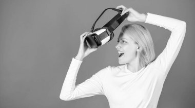 VR gözlük takan genç bir kadının portresi, 3 boyutlu kulaklık kullanarak sanal gerçekliği deneyimliyor. Sanal gerçeklik kulaklığı olan bir kadın. Kendine güvenen genç bir kadın sanal gerçeklik kulaklığını ayarlıyor ve gülümsüyor..