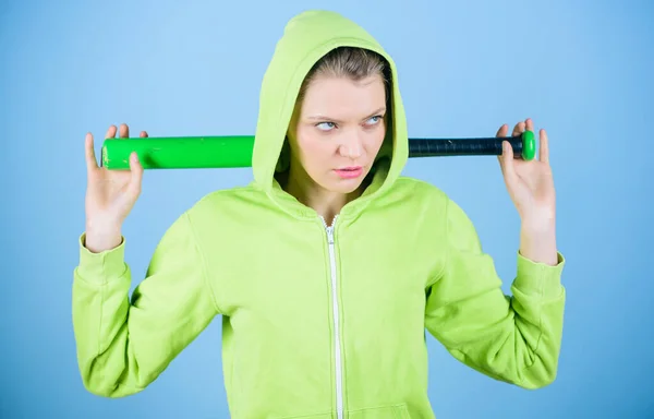 Bruut en pestkop. Vrouw speelt honkbal of gaat iemand verslaan. Vrouw in de honkbalsport. Honkbal vrouwelijke speler concept. Ze is gevaarlijk. Meisje capuchon jas hold honkbal vleermuis blauwe achtergrond — Stockfoto