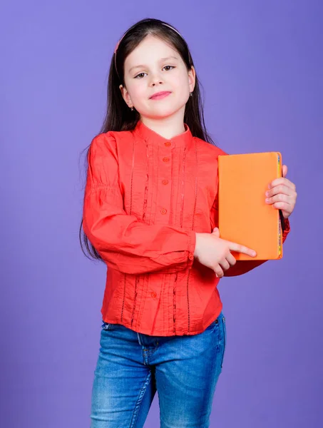 Published information. Small child holding book with orange cover for vital information. Little girl with information materials. Information from reliable sources, copy space — Stock Photo, Image
