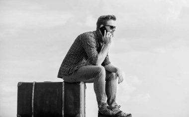 Klasik valizli bir adam. Bagaj konsepti. Taksi çağırıyorum. Seyahat acentesi. Bagajla seyahat et. Gezgin blogcu. İnsan yolculuktan önce bavula oturur. İş gezisi. Yakışıklı gezgin.