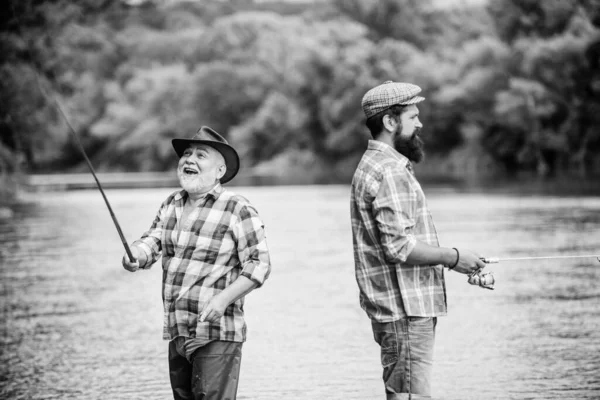 Good days. two happy fisherman with fishing rod and net. father and son fishing. hobby and sport activity. Trout bait. male friendship. family bonding. summer weekend. mature men fisher — Stock Photo, Image