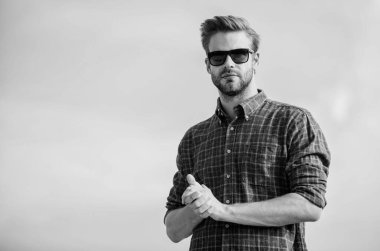 Erkek gözlüklü model açık havada mavi gökyüzü arka planı. Yakışıklı adam güneş gözlüğü takıyor. Moda güneş gözlüklü hippi. Ultraviyole koruma kavramı. Mükemmel görüş. Göz sağlığı. Moda güneş gözlüğü.