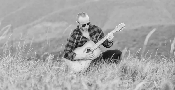 Keep calm and play guitar. Man with guitar on top of mountain. Acoustic music. Music for soul. Playing music. Sound of freedom. In unison with nature. Musician hiker find inspiration in mountains