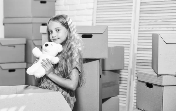 新しい家に興奮してた。女の子の子供は箱の近くでおもちゃで遊ぶ。コンセプトを変えなさい。移動の準備を。出て行け。荷物をまとめて。賃貸住宅。家族の家だ。サービスを提供する。家族のためのアパート — ストック写真