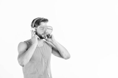 DJ çocuk. Teknoloji ve eğlence. Modern hayat. Kulaklık ve güneş gözlüklü yakışıklı adam. Parti konsepti. Yaz müzik çizelgesi. Popüler yaz şarkıları listesi. Tıraşsız adam yaz müziğini dinliyor.