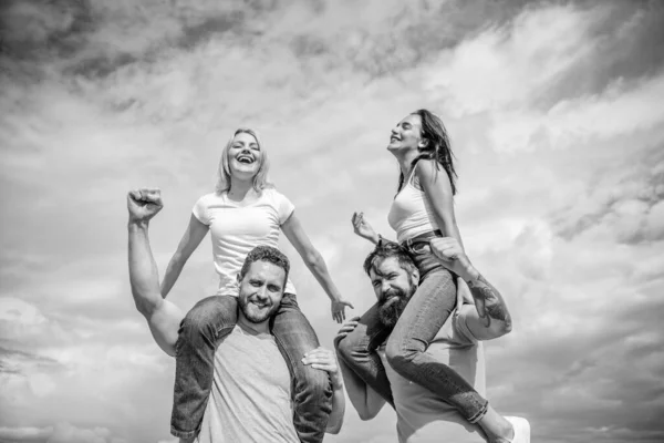 Twice fun on double date. Couples in love having fun. Men carry girlfriends on shoulders. Summer vacation and fun. Couples on double date. Inviting another couple to join. Friendship of families — Stock Photo, Image