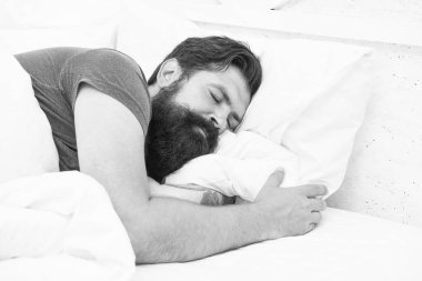 Gömlekli, yakışıklı, olgun bir adam yatakta uyuyor, sağlıklı bir uyku çekiyor.