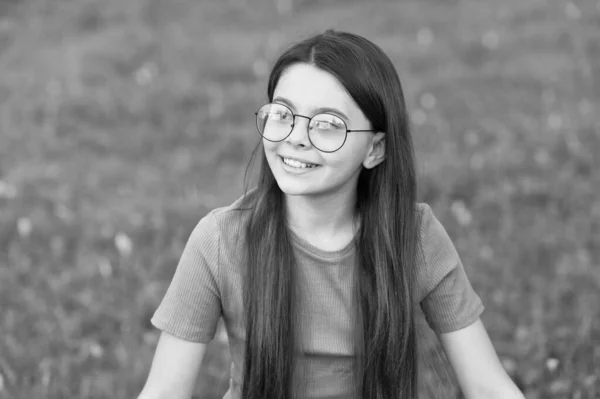 Mała dziewczynka nosić vintage rim okulary zielone tło trawnik, świeże powietrze koncepcja — Zdjęcie stockowe
