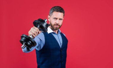 Güçlü teknik direktör dambıl egzersizi kırmızı arka plan, iş