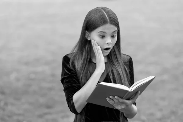 Verrassing helpt om nieuwe dingen te bestuderen. Verrast kind lezen studie boek buiten. Kennis en informatie. Schoolbibliotheek. Onderwijs lezen. Motivatie en interesse. Aandacht trekken van lerenden — Stockfoto