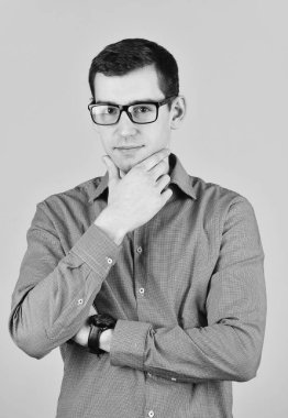 Gözlüklü yakışıklı adam çeneye dokunuyor. Tıraşsız ve gözlüklü bir adamın dostane portresi. Zeki görünümlü bir iş adamı. Başarılı bir iş adamı. Erkek kendinden emin hissediyor. Gözlüklü yakışıklı adam.