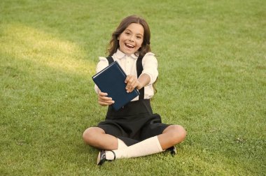 Eğitim için harika bir yer. Küçük kız kitap okuyor. Çocuklar için edebiyat. çocukluk anıları yaz. Not defterine not alıyorum. Okula dönüyorum. Çocuk parkta ders çalışıyor. Yeşil çimlerde kitap okuyarak rahatla.