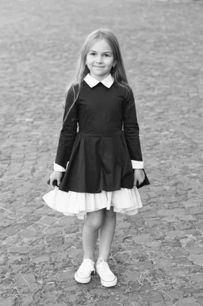 Happy little kid wear school uniform dress code in formal style outdoors, fashion