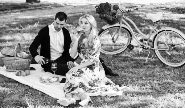 First Date Ideas Guaranteed to Win Her Heart. Enjoying their perfect date. Happy loving couple relaxing in park with food. Romantic picnic with wine. Couple in love picnic date. Spring weekend — Stock Photo, Image