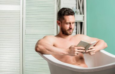 Rahat ol. Kaslı gövde, küveti gevşet ve kitap oku. Sıcak bir banyoda rahatlarken kitap okuyan rahat adam. Evinde dinlen. Tam bir rahatlama. Kişisel hijyen. Sinir sistemi banyoları