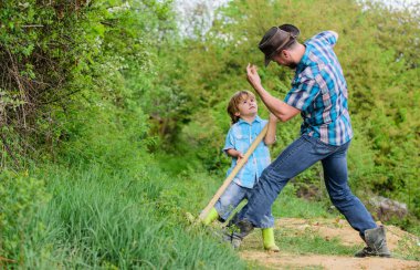 Hazineler için macera avcılığı. Bahçedeki küçük yardımcı. Doğadaki sevimli çocuk, eğlenceli kovboy babası. Hazineleri bul. Kürekle hazine arayan küçük bir çocuk ve babası. Macera ruhu.