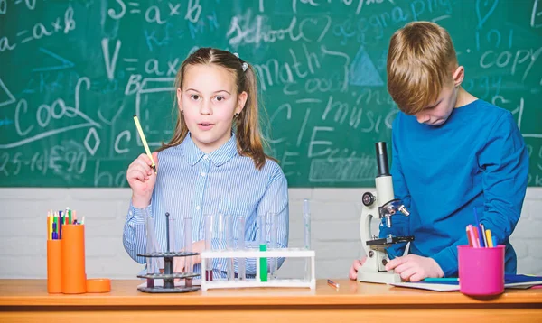 Okul eğitimi. Kimyasal analiz. Çocuklar kimya okuyor. Okulun kimya dersi. Okul laboratuarı. Kız ve erkek okul deneyi sırasında iletişim kurarlar. Çocuklar birlikte ders çalışıyor.