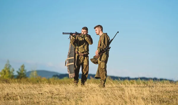 Friendship of men hunters. Military uniform fashion. Army forces. Camouflage. Hunting skills and weapon equipment. How turn hunting into hobby. Man hunters with rifle gun. Boot camp. Bang.